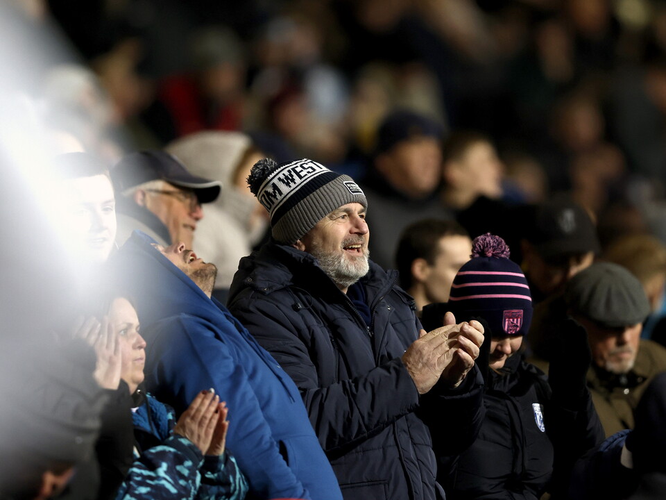 An image of an Albion supporter applauding the team