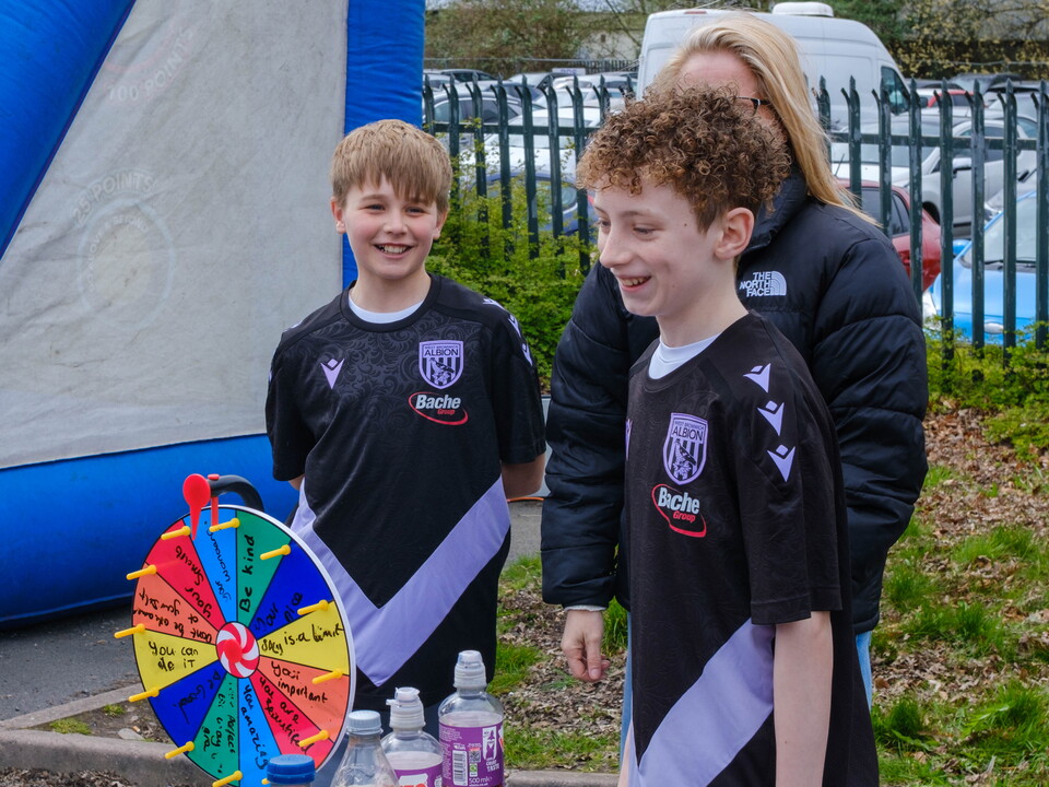 Two students smiling behind their display table in the WBA Fanzone
