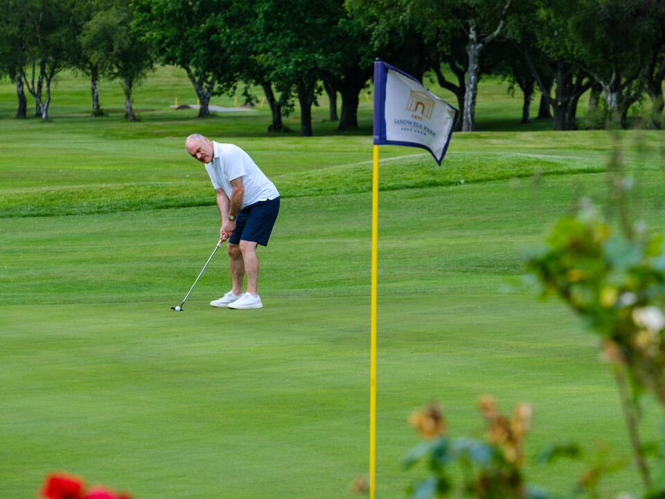 Gavin Whitehouse on the green with the Sandwell Park Golf Club hole flag in the foreground.