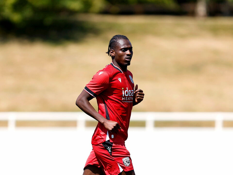 Ousmane Diakité in action for Albion in red away colours.