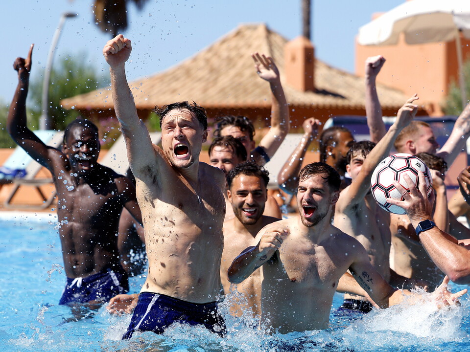 Callum Styles and several other WBA players celebrate in the pool during a recovery session game