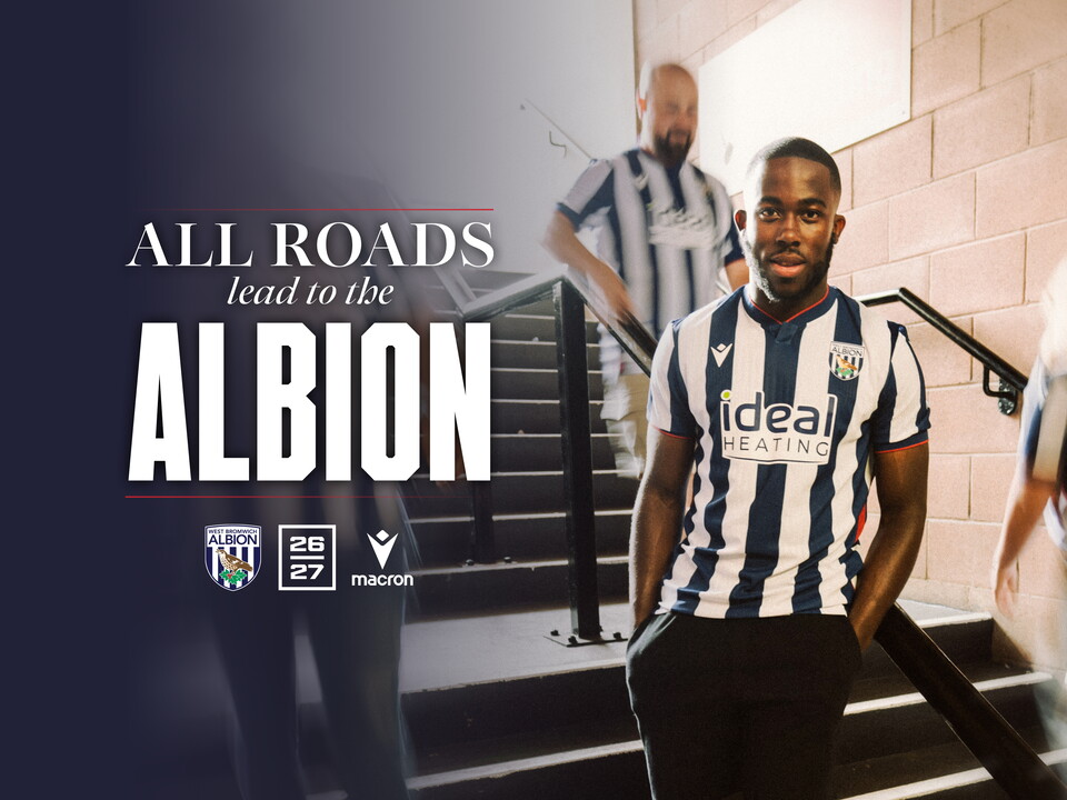 An image of a WBA fan posing in the new home kit on some steps 