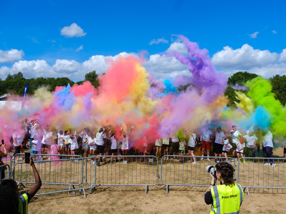 Participants at Blind Dave's Colour Run throwing paint in the air