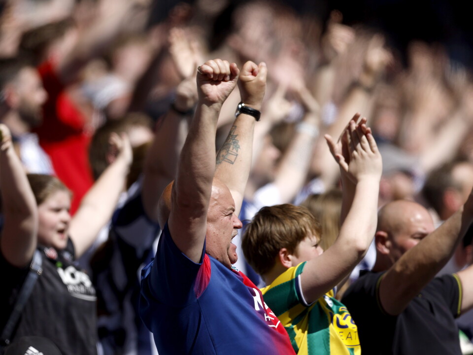 WBA fans cheering with their arms in the air 