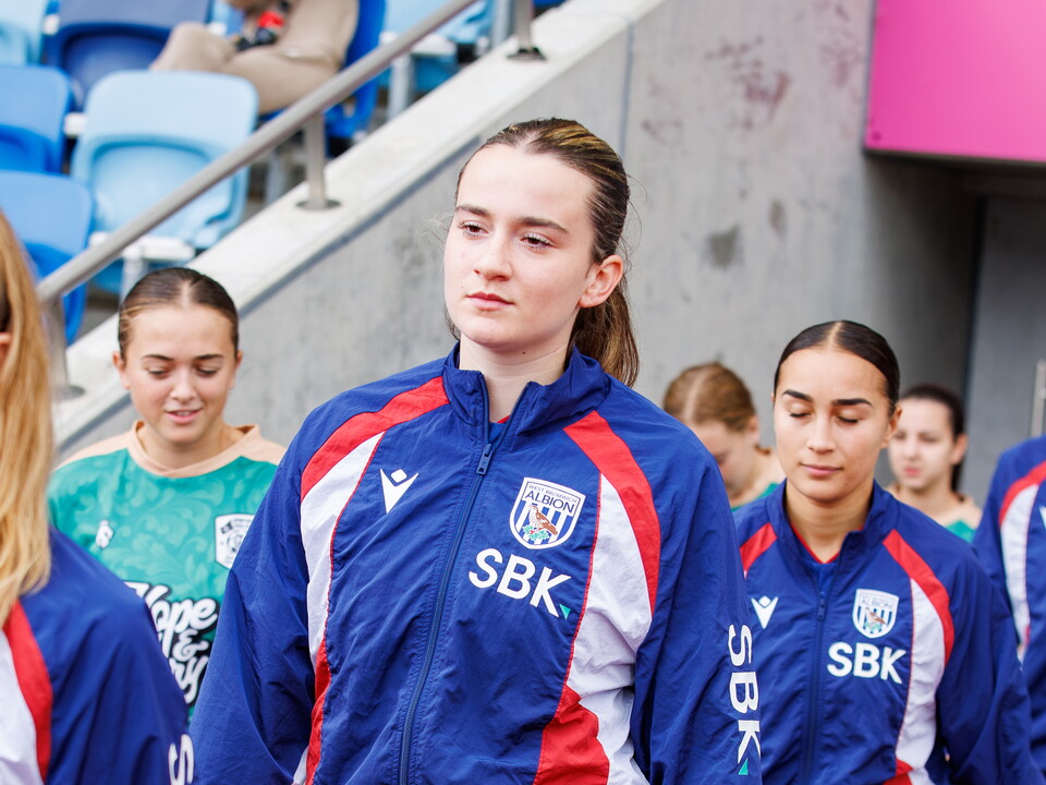 Lucy Day walking out of the tunnel before a game in the WBA tracksuit 
