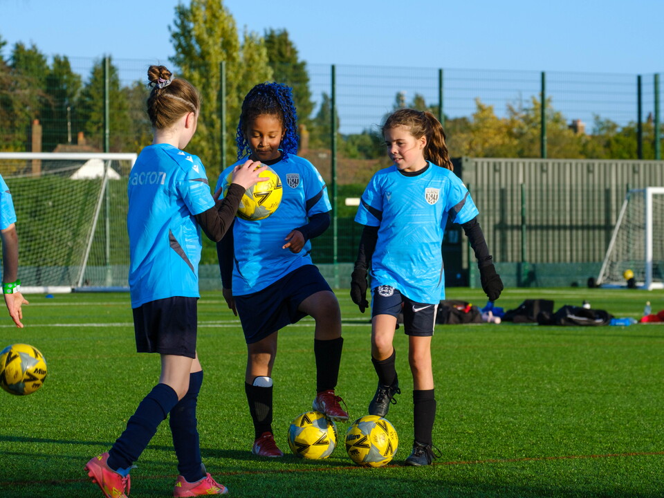 Three players gathered together with footballs.