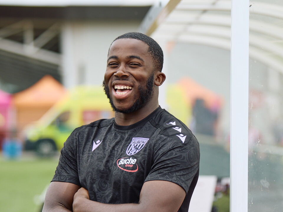 Kadeem Jordan smiling while looking at the camera with his arms crossed
