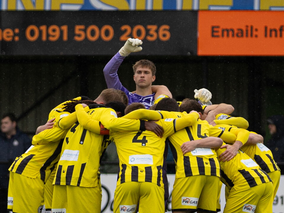 Joe Wallis in a team huddle with Chester players before a game